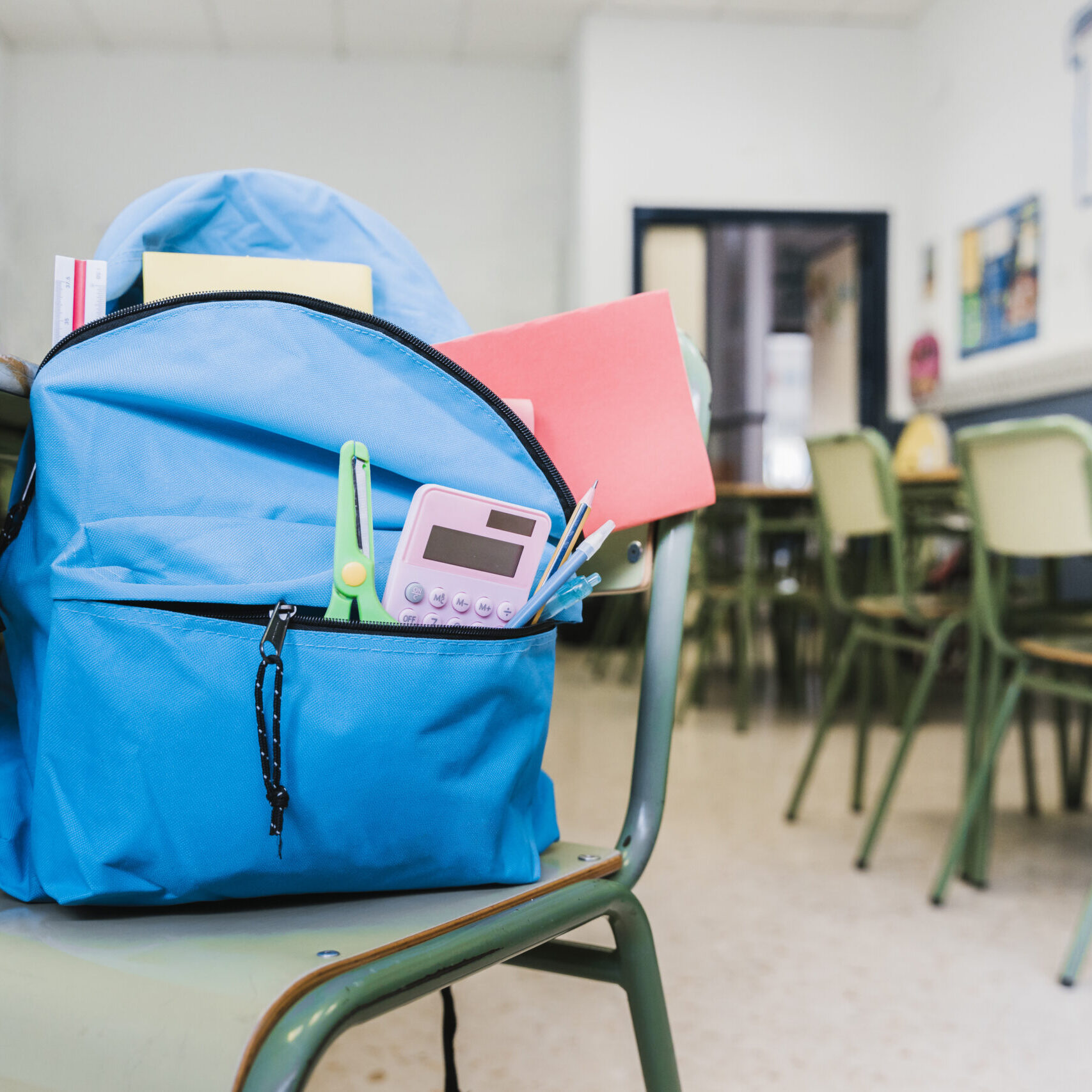 school-backpack-with-supplies-on-chair